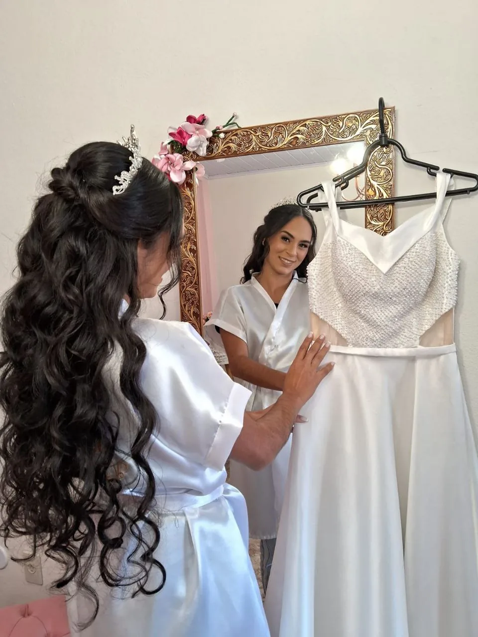 Noiva se preparando ao lado do vestido no studio